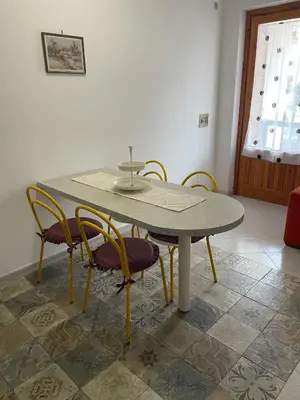 a dining room table with chairs and a table and a table and chairs at Turisti a Casa in San Vito lo Capo