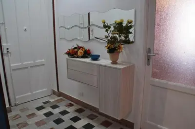 a bathroom with a dresser with a mirror and flowers at B&T Holiday House in Palermo