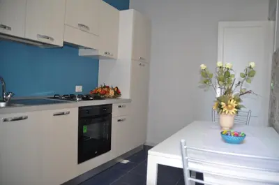 a kitchen with a table with a vase of flowers on it at B&T Holiday House in Palermo