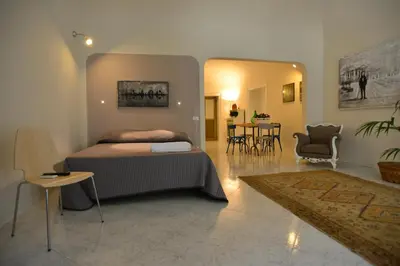 a bedroom with a bed and a table and chairs at La Locanda dei Corrieri in Palermo