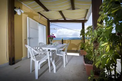 a white table and chairs on a patio with plants at Casa Vacanza Saraceno in Castellammare del Golfo