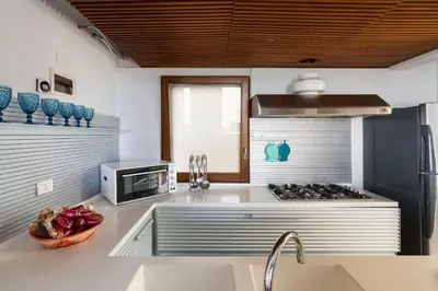 a kitchen with a sink and a stove top oven at Casa del Rais con accesso privato al mare in Santa Flavia