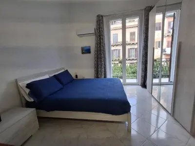 a bed with blue sheets in a room with a window at Casa Maria Rosa Deliziosa in Palermo
