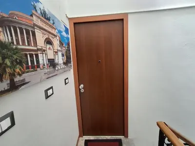 a wooden door on a wall with a painting at Casa Maria Rosa Deliziosa in Palermo