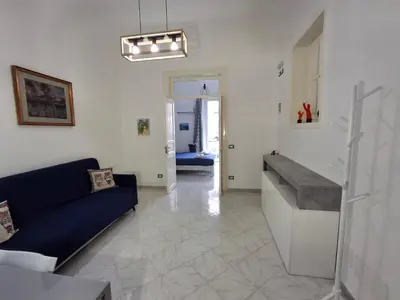 a living room with a blue couch and a sink at Casa Maria Rosa Deliziosa in Palermo