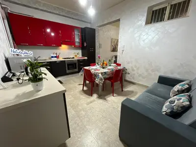 a kitchen and a living room with a table and a couch at Sweet Home Pietro e Lia by Holiday World in Casteldaccia