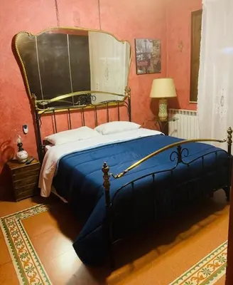 a bedroom with a blue bed with a large mirror at L'abete in Villabate