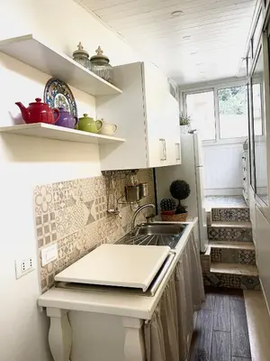 a kitchen with white cabinets and a sink at Marina Mondello House comfort in Mondello