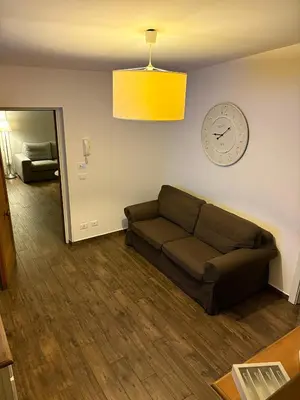 a living room with a couch and a clock on the wall at Marina Mondello House comfort in Mondello