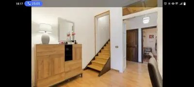 a living room with a staircase and a room with a table at Palermo sweet house in Palermo