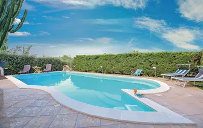 a swimming pool with two chairs and a table at Doppia villa indipendente/clara in Mandra Capreria