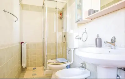 a bathroom with a toilet and a sink and a shower at Doppia villa indipendente/clara in Mandra Capreria