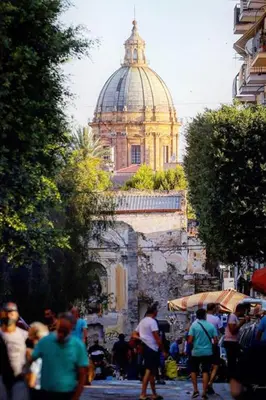 a group of people walking down a street with a cathedral at La Casa di Elisa Mini Apartment - Palermo in Palermo