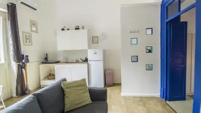 a living room with a couch and a kitchen at Cappuccini 145 R&P -Parcheggio gratis-Centro Storico-Cattedrale in Palermo