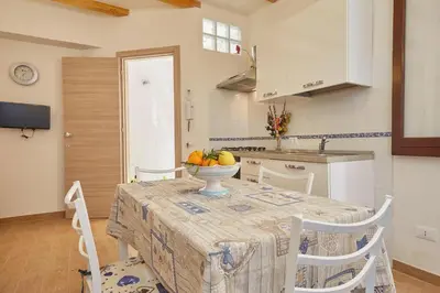 a kitchen with a table with a bowl of fruit on it at CASA FATIMA in Castellammare del Golfo