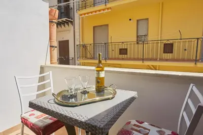 a bottle of wine sitting on a table with glasses at CASA FATIMA in Castellammare del Golfo