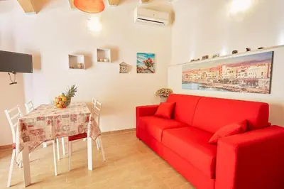 a living room with a red couch and a table at CASA FATIMA in Castellammare del Golfo