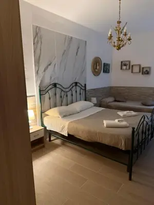a bedroom with a blue bed and a chandelier at Al Vicolo in Palermo