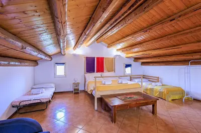 a large room with two beds and a table at Casa Querencia rooms in Palermo