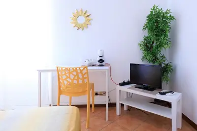 a room with a desk with a television and a chair at Casa Querencia rooms in Palermo