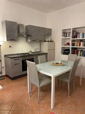a kitchen with a white table and chairs in a kitchen at FINESTRA SUL MARE in Palermo