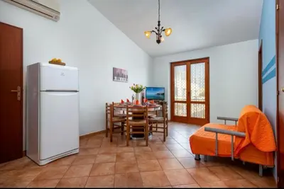 a kitchen and dining room with a refrigerator and a table at Marconi in San Vito lo Capo