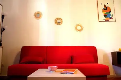 a red couch in a living room with a table at Wood House - Palermo in Palermo