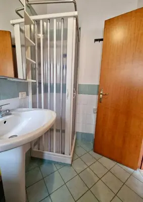 a bathroom with a sink and a glass shower door at Wood House - Palermo in Palermo