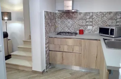 a kitchen with a stove and a microwave at Ancilinas House in Castellammare del Golfo