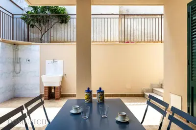 a table with two chairs and a toilet in a room at La Dimora del Mare by Domus Sicily in Mondello