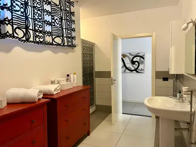 a bathroom with a sink and a toilet and a mirror at Flat with Terrace & Pool in Mondello