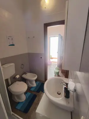 a bathroom with a white toilet and a sink at Casa Swamy in Palermo