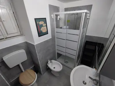 a bathroom with a toilet sink and a shower at Montesanto Home in Palermo