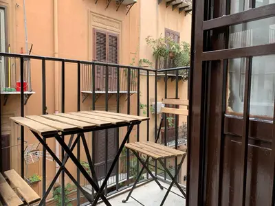 a balcony with a wooden table and two chairs at Montesanto Home in Palermo