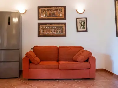 an orange couch in a living room with a refrigerator at VILLA ANGELA TRABIA in Trabia
