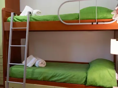 a bunk bed with green sheets and towels on it at VILLA ANGELA TRABIA in Trabia