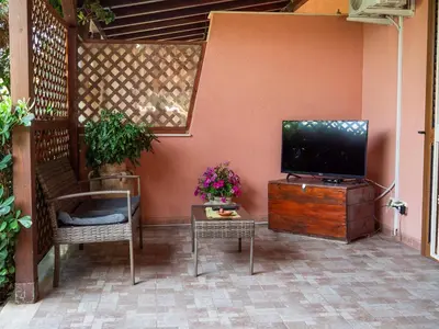 a flat screen tv sitting on a wooden stand next to a wall at VILLA ANGELA TRABIA in Trabia