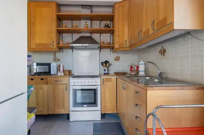 a kitchen with wooden cabinets and a white stove top oven at Kastemar in Porticello