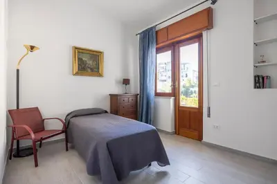 a bedroom with a bed and a chair and a window at Kastemar in Porticello