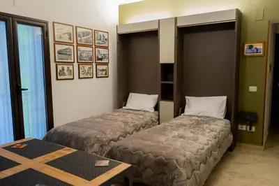 a hotel room with two beds and a table at Le Case Di Romeo Alla Vucciria in Palermo