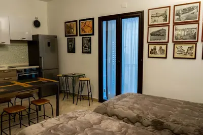 a bedroom with a bed and a kitchen with a table at Le Case Di Romeo Alla Vucciria in Palermo