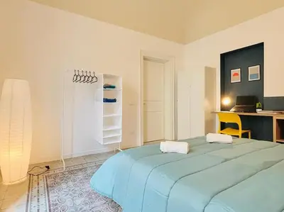 a large blue bed in a room with a desk at Corte del Tribunale in Palermo
