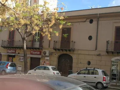 a building with cars parked in front of it at Corte dei Re di Palermo Apartment in Palermo