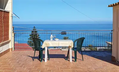 a table and chairs on a balcony with the ocean at VISTA MARE in Alcamo Marina