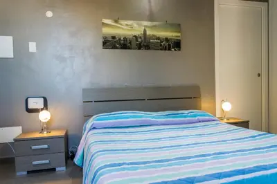 a bedroom with a bed and two night stands with lamps at Villa Giambona in Isola delle Femmine