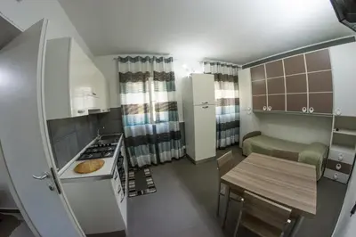 a small kitchen with a table and a refrigerator at Villa Giambona in Isola delle Femmine