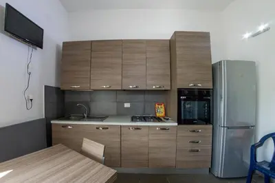 a kitchen with wooden cabinets and a stainless steel refrigerator at Villa Giambona in Isola delle Femmine
