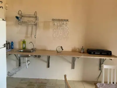 a kitchen with a counter with a sink and a shelf at casa di campagna iobio in Alcamo