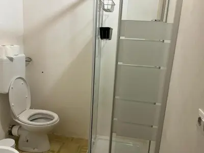 a bathroom with a toilet and a glass shower stall at casa di campagna iobio in Alcamo