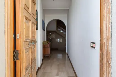 a hallway with a wooden door and a hallway with a staircase at Villa Emilia Mondello Appartamento Emily con vista sul mare in Palermo